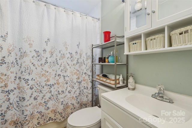 bathroom featuring vanity, a shower with shower curtain, and toilet