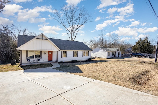 view of front of property featuring covered porch, a front yard, and central AC