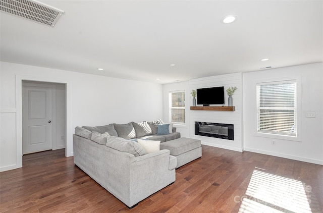 living room with dark hardwood / wood-style floors and a fireplace