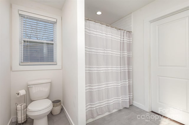 bathroom with toilet and a shower with curtain