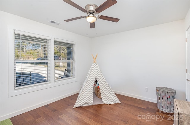 playroom with ceiling fan and dark hardwood / wood-style flooring