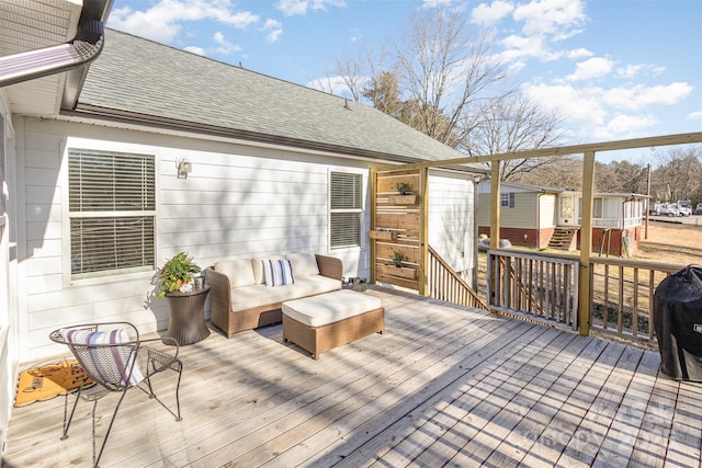 wooden deck with an outdoor hangout area and grilling area