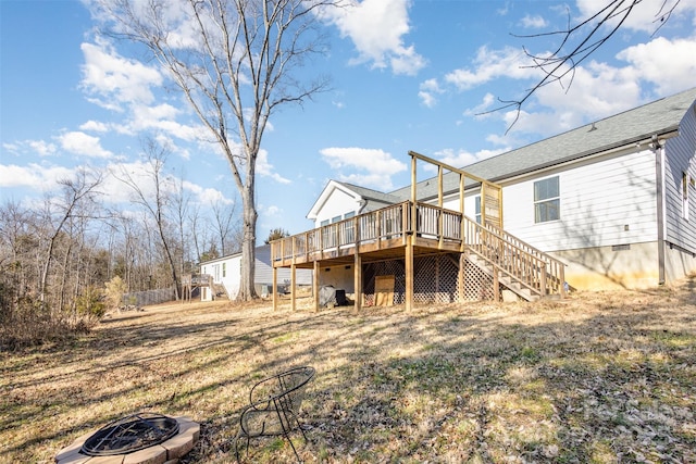 back of house featuring a wooden deck and a fire pit