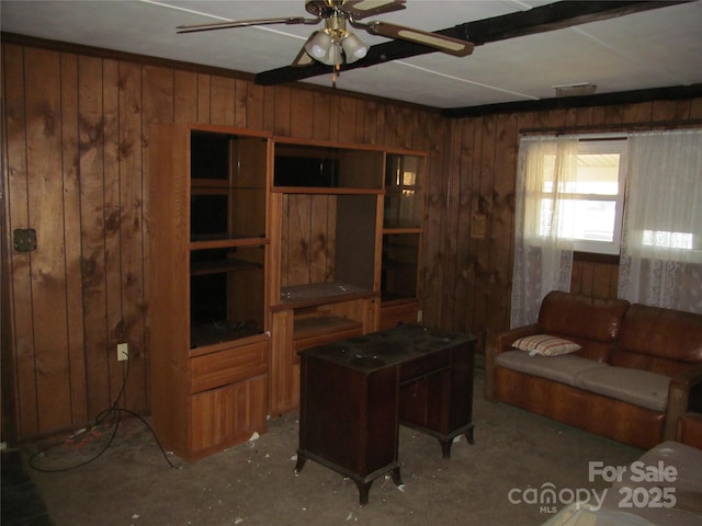 living room with ceiling fan and wood walls