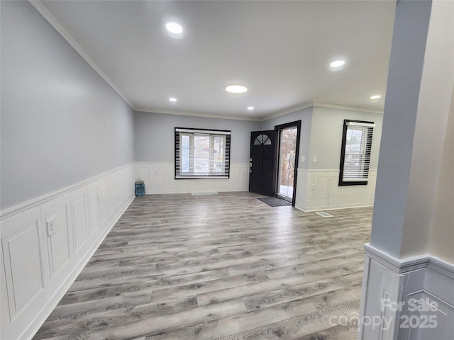 interior space featuring ornamental molding, a healthy amount of sunlight, and light hardwood / wood-style floors