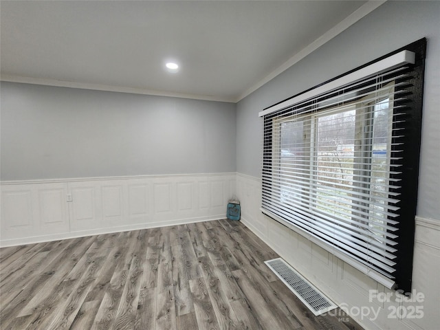 spare room with wood-type flooring and ornamental molding