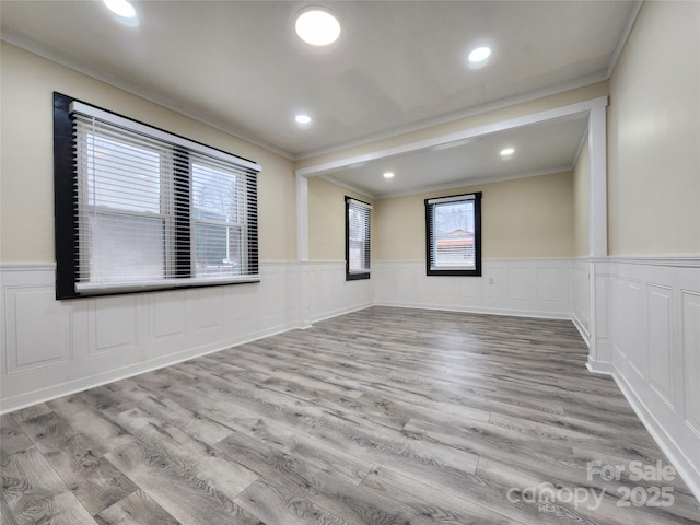 unfurnished room with light wood-type flooring and crown molding