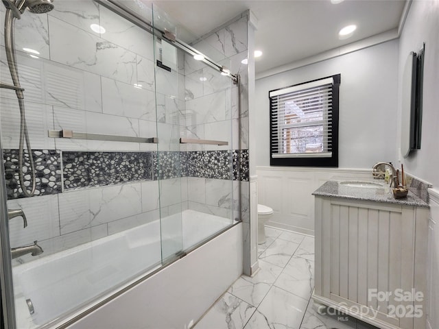 full bathroom featuring toilet, bath / shower combo with glass door, and vanity