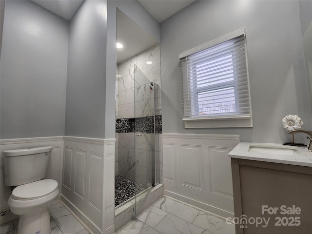 bathroom with toilet, a shower with door, and vanity