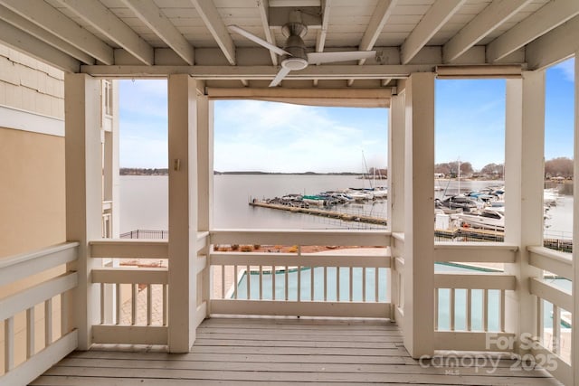 wooden terrace featuring a ceiling fan and a water view