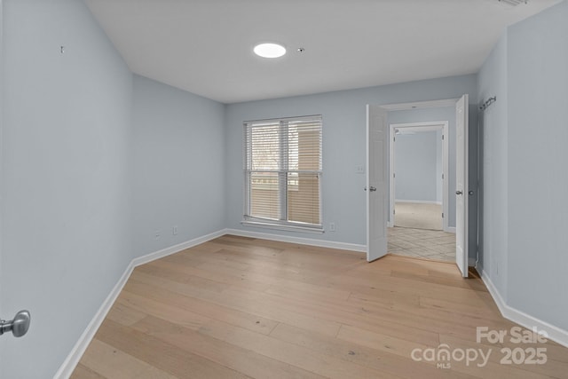 unfurnished room featuring light wood-style floors and baseboards