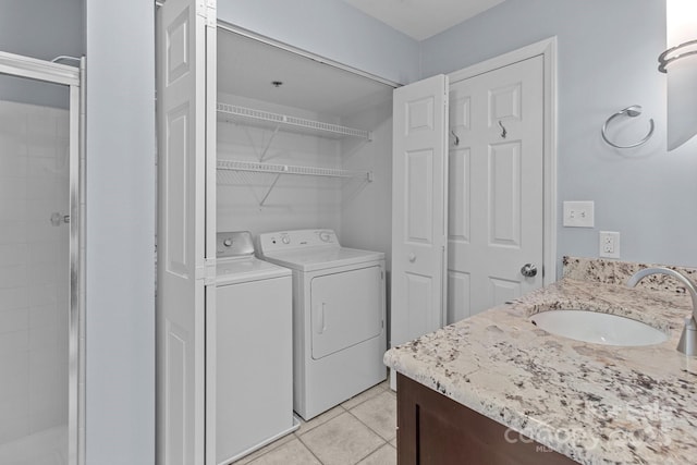 laundry area with washer and dryer, a sink, laundry area, and light tile patterned floors