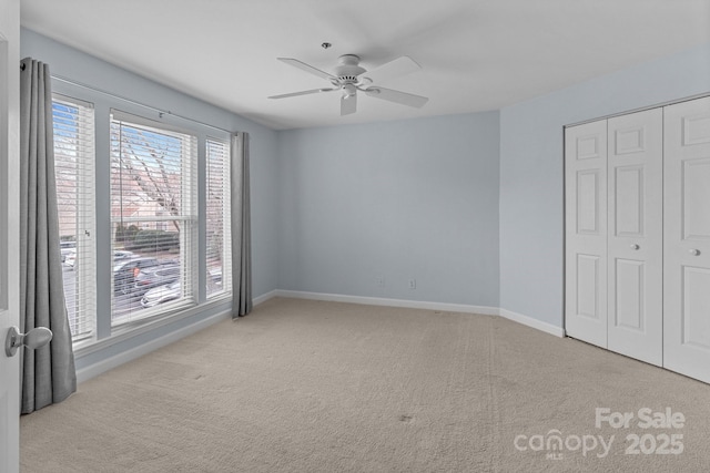 unfurnished bedroom featuring baseboards, carpet flooring, and multiple windows
