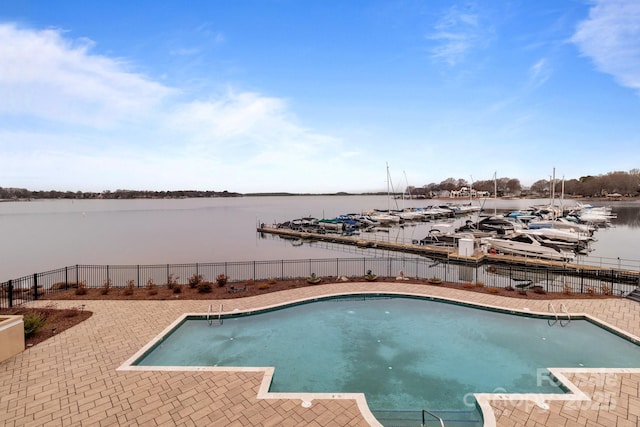 view of pool featuring a fenced in pool, a patio, a water view, and fence