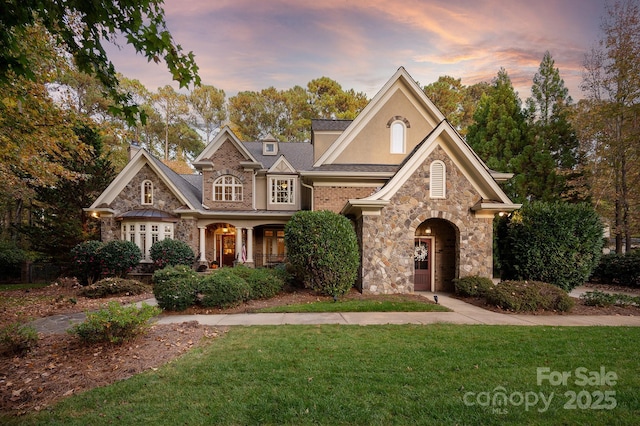 view of front of house with covered porch and a yard