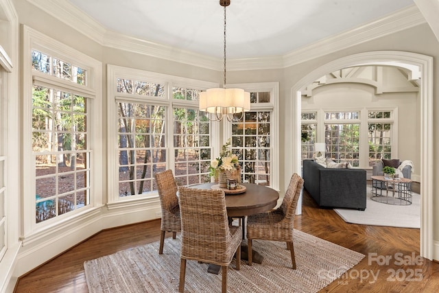 sunroom / solarium featuring an inviting chandelier and plenty of natural light