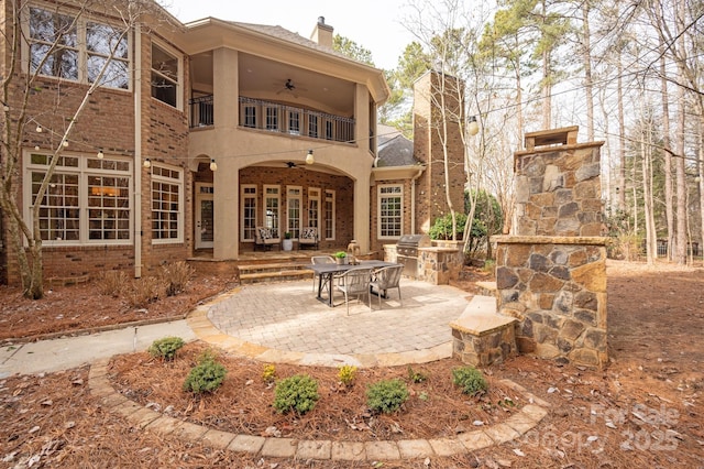 back of house featuring ceiling fan, a balcony, a patio area, and area for grilling