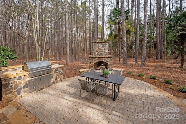 view of patio with exterior kitchen, grilling area, and an outdoor stone fireplace