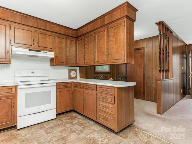 kitchen featuring electric stove, wooden walls, and kitchen peninsula