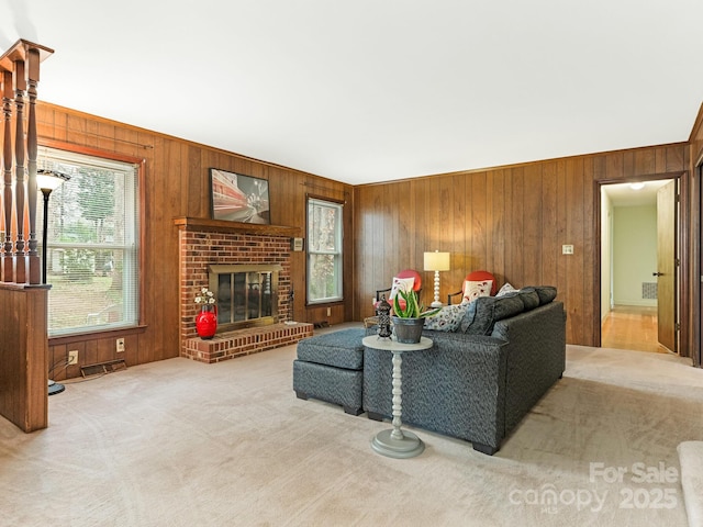 living room with a fireplace, carpet floors, and wooden walls