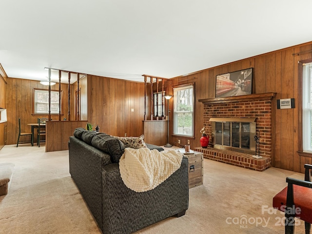 living room featuring light carpet, wooden walls, and a brick fireplace