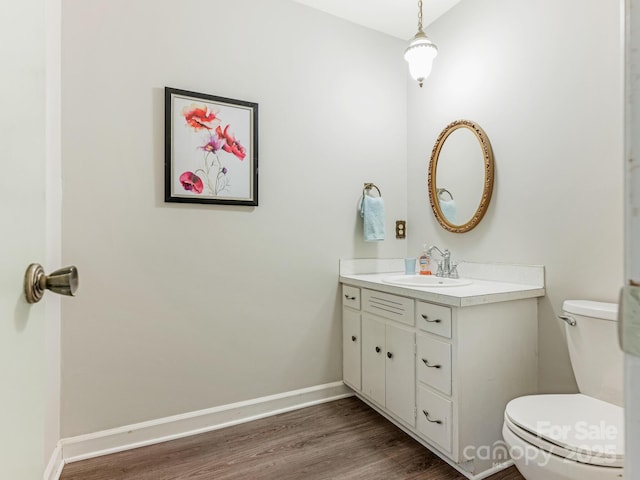 bathroom featuring hardwood / wood-style flooring, vanity, and toilet