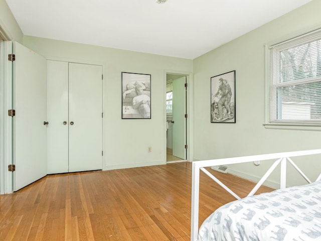 bedroom with light wood-type flooring and a closet