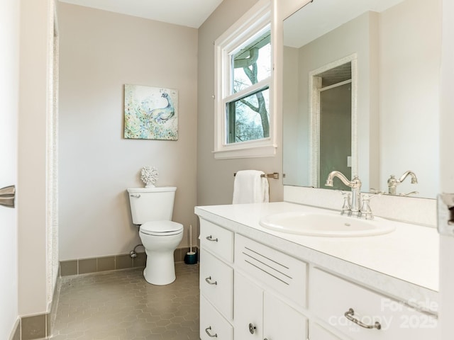 bathroom featuring tile patterned flooring, vanity, and toilet