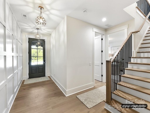 entryway featuring an inviting chandelier and hardwood / wood-style flooring