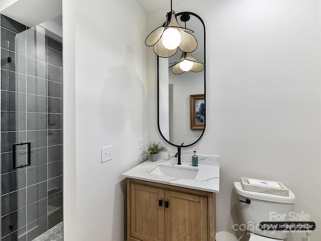 bathroom with vanity, toilet, and a tile shower