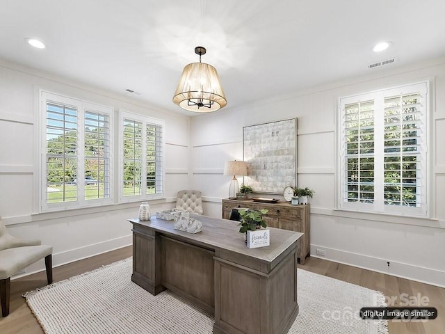 office space featuring hardwood / wood-style flooring and crown molding