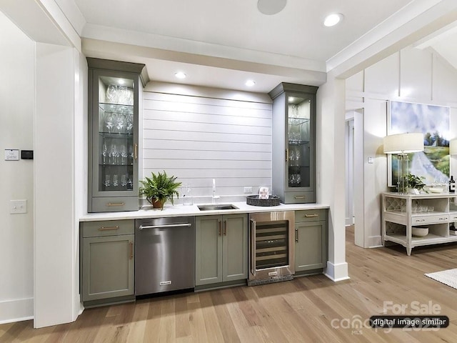 bar featuring stainless steel dishwasher, ornamental molding, sink, light hardwood / wood-style flooring, and wine cooler