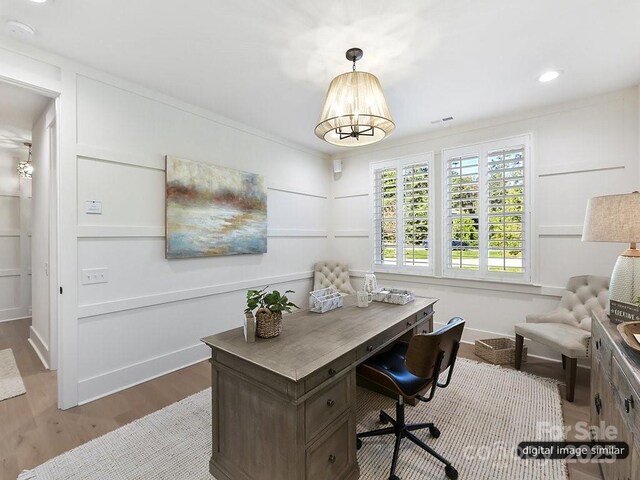 office area with wood finished floors, a chandelier, crown molding, and baseboards