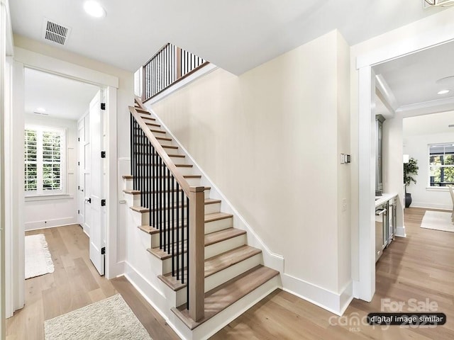 staircase featuring wood finished floors, baseboards, and recessed lighting