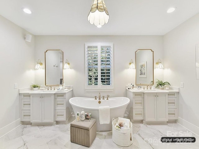 bathroom featuring baseboards, marble look tiles, a soaking tub, two vanities, and recessed lighting