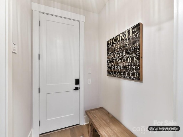doorway with wood finished floors and baseboards