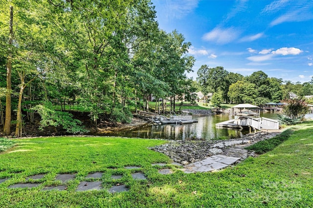 exterior space with a water view, a lawn, and a dock