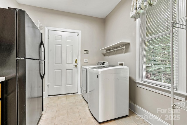 washroom with separate washer and dryer and light tile patterned flooring