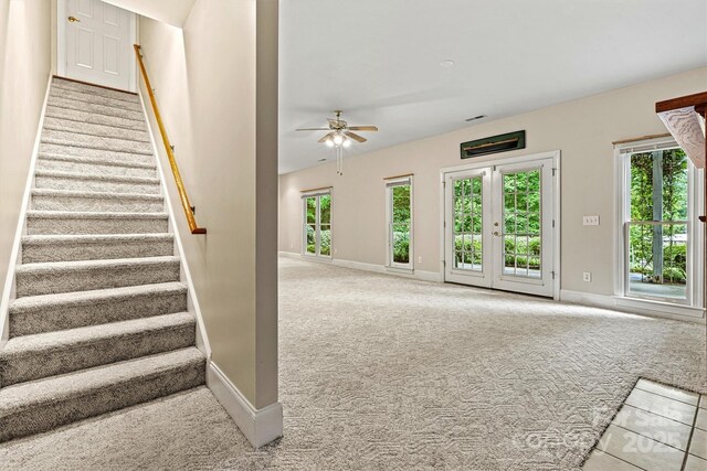 stairway featuring ceiling fan and carpet