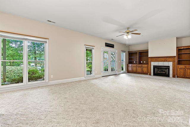 unfurnished living room featuring ceiling fan, a fireplace, and carpet