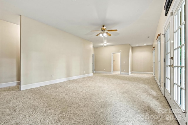 carpeted empty room with ceiling fan, french doors, and a healthy amount of sunlight