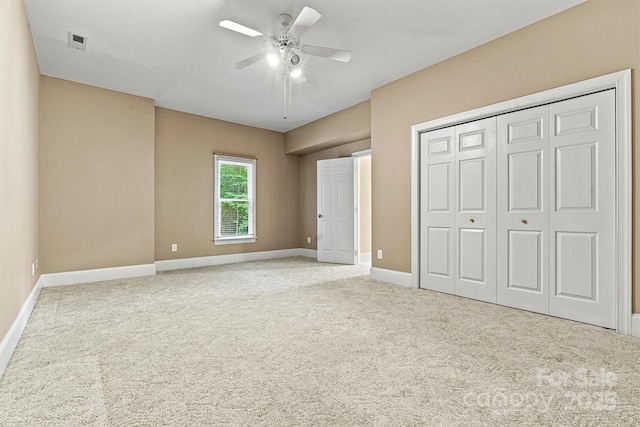 unfurnished bedroom with ceiling fan, a closet, and light carpet