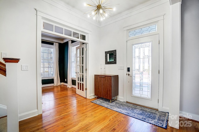 foyer entrance with a notable chandelier and hardwood / wood-style flooring