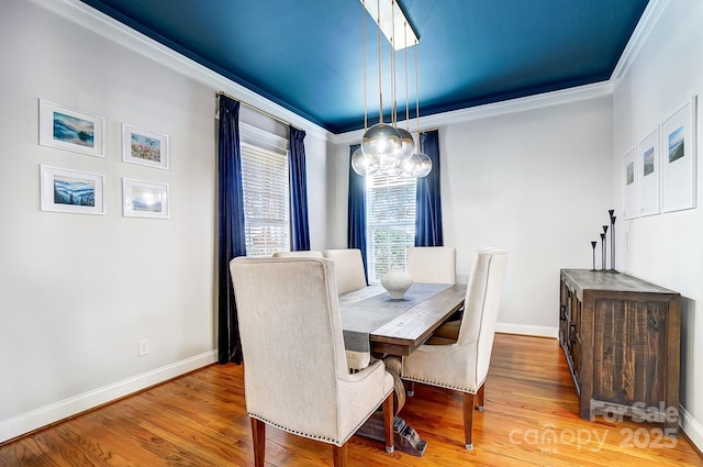 dining area with hardwood / wood-style flooring and ornamental molding