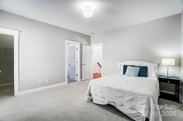 bedroom featuring carpet flooring, a spacious closet, a closet, and ensuite bathroom