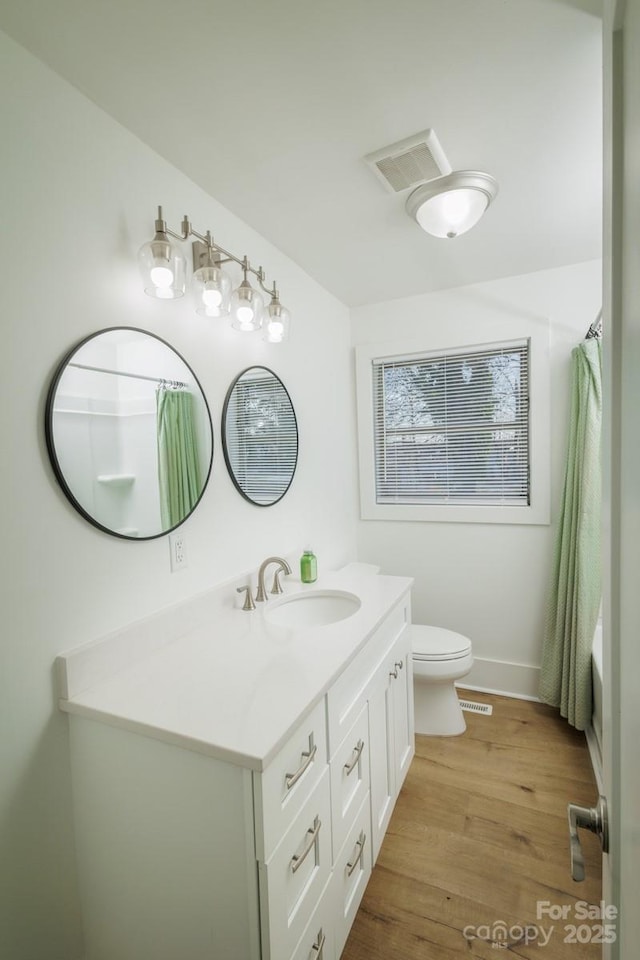 bathroom with vanity, toilet, hardwood / wood-style floors, and curtained shower