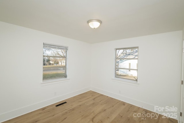 unfurnished room with hardwood / wood-style floors