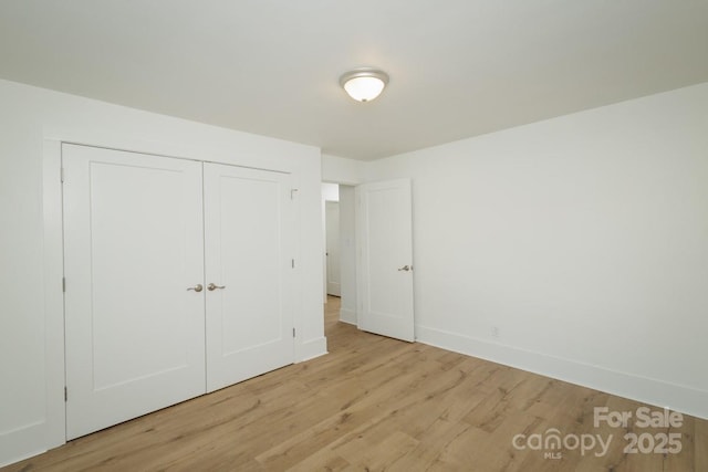 unfurnished bedroom featuring a closet and light wood-type flooring