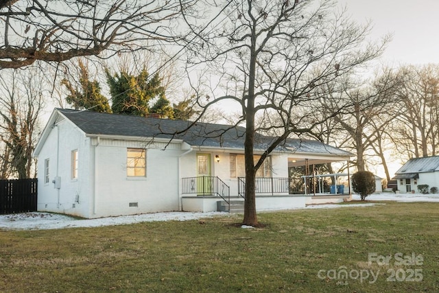 rear view of house featuring a yard