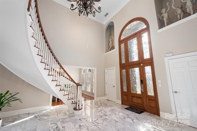 foyer featuring french doors, a towering ceiling, a wealth of natural light, and ornamental molding